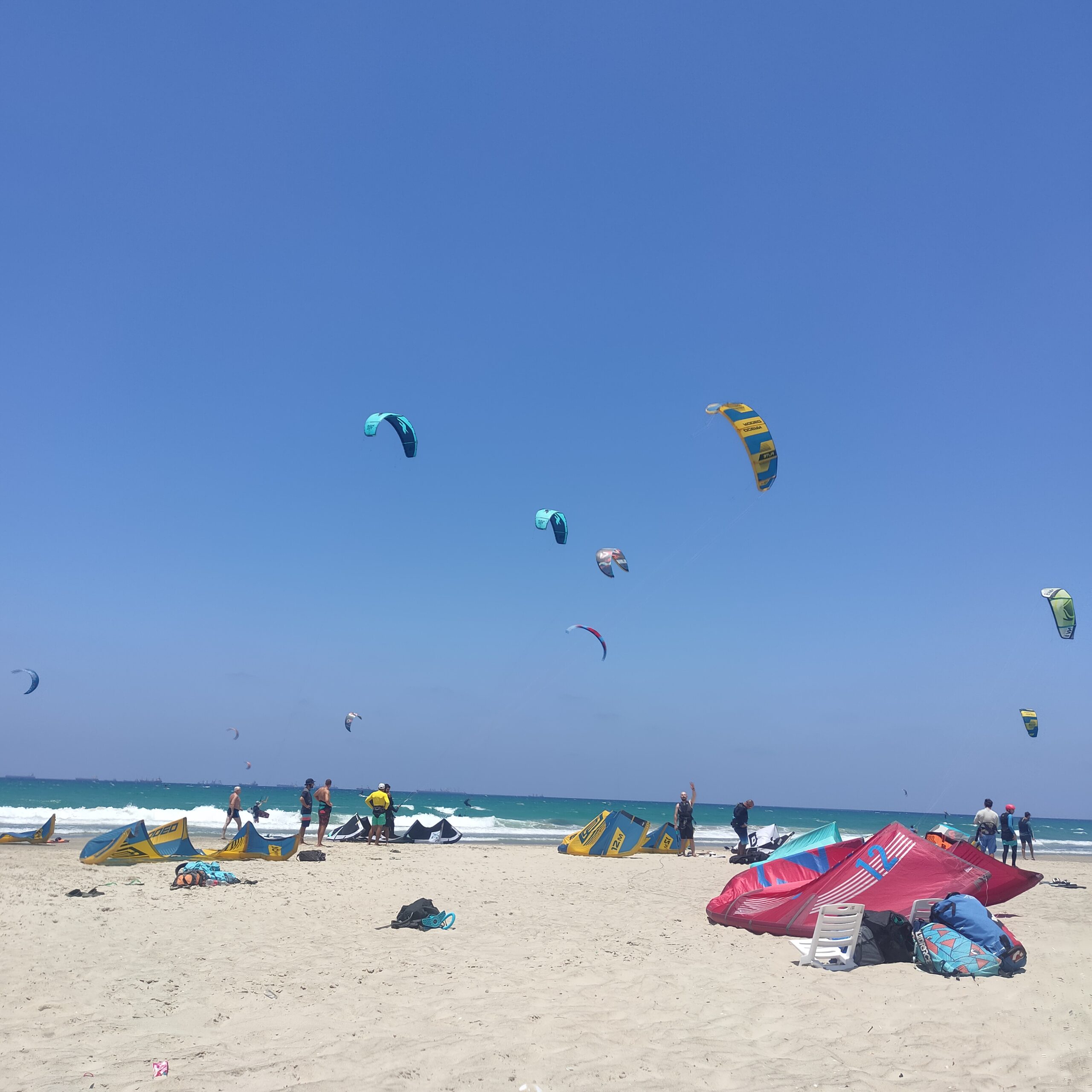 kitesurfing safety guide showing kitesufer checking conditions on beach before launching